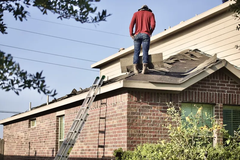 Professional roofer working on a residential roof in Adams Corners